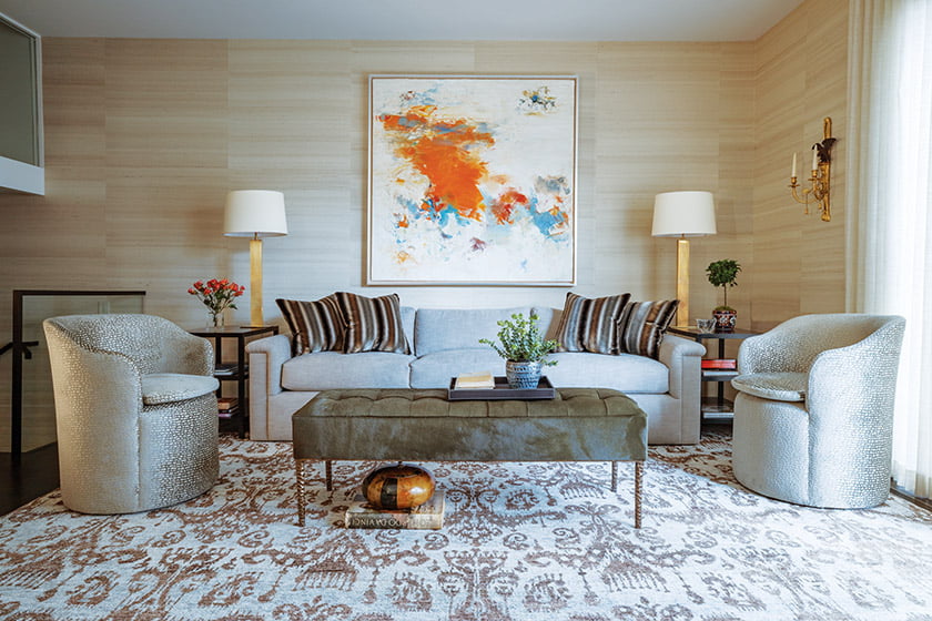 The family room marries a tufted-leather ottoman, swivel chairs in chenille and a painting from Merritt Gallery.