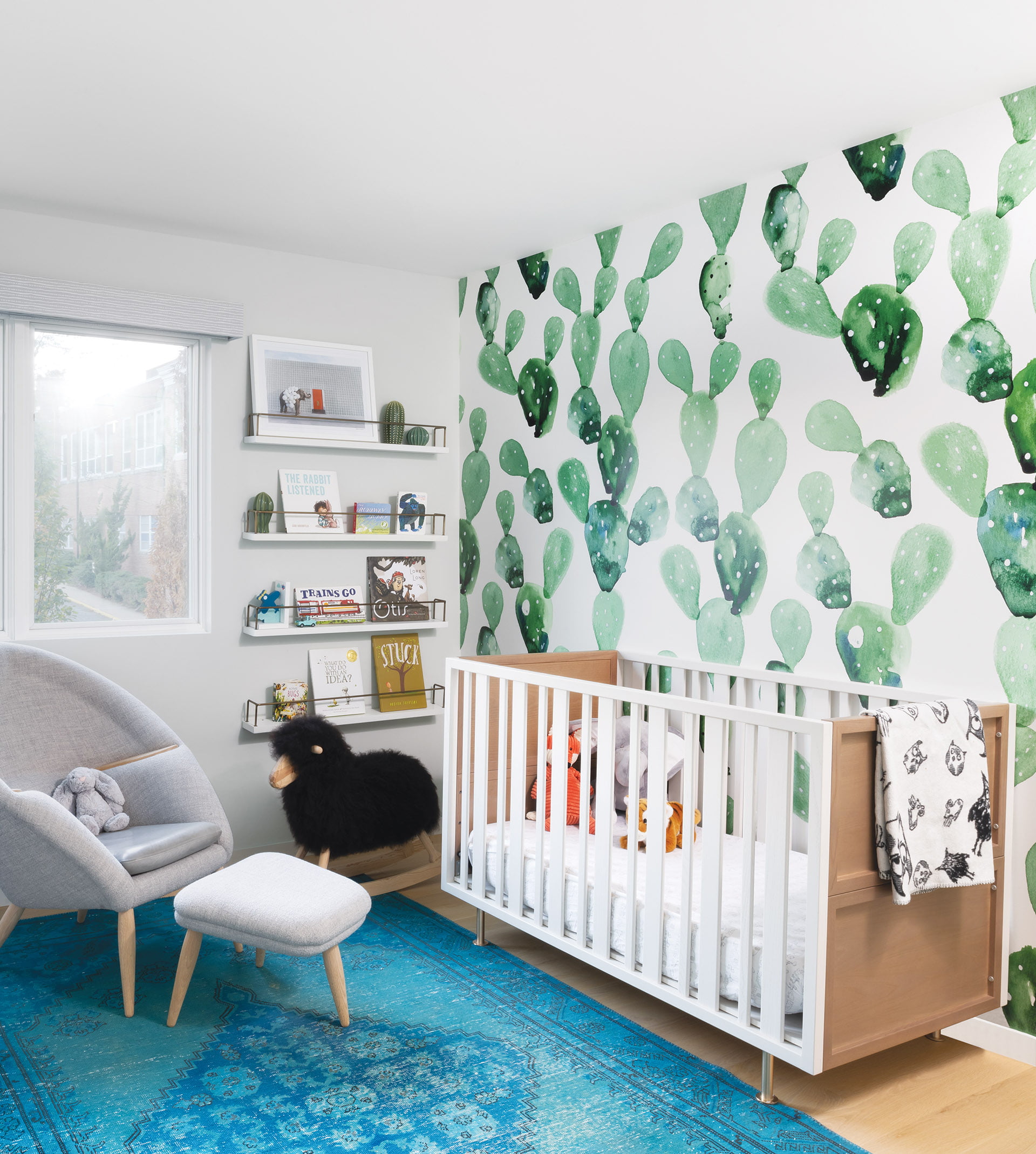 Anewall mural accents the nursery, Oda chair and ottoman by Nanna Ditzel, and overdyed vintage rug from Timothy Paul.