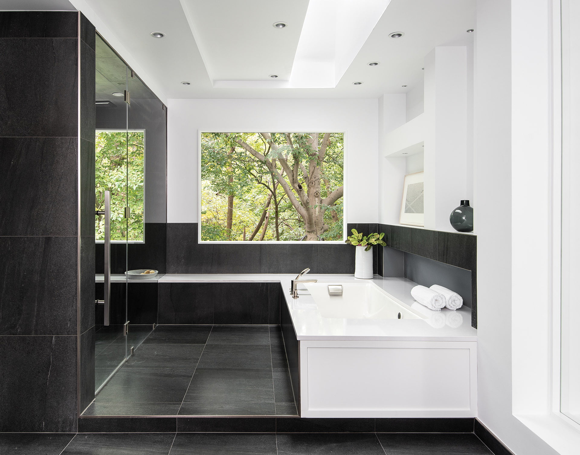 White accents and charcoal-gray porcelain tile on the walls and heated floors