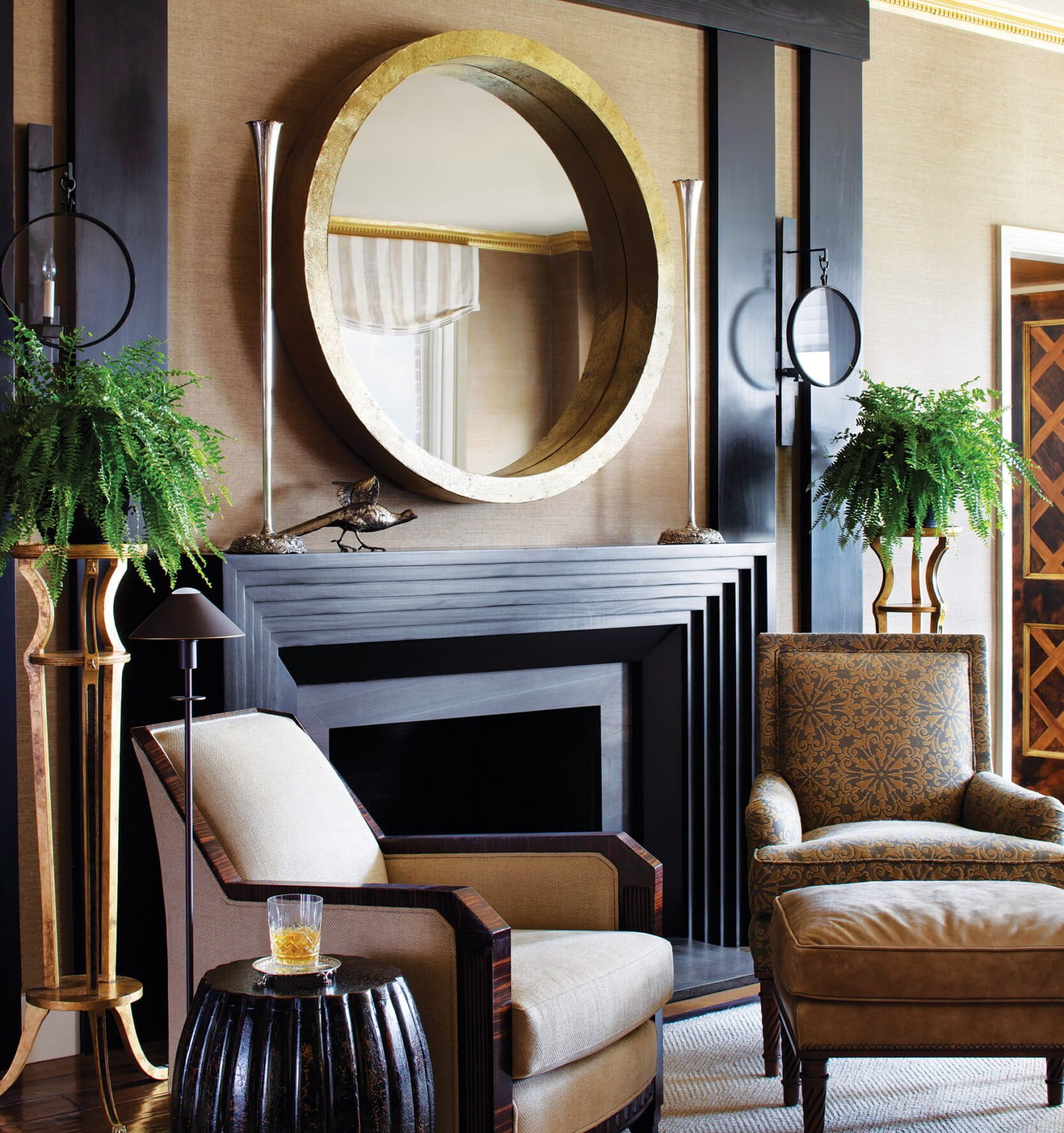 Contrasted angles of the Art Deco-style fireplace with a round gold-leaf mirror by Interlude Home.
